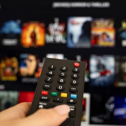 Woman hand holding tv remote.