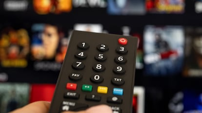 Woman hand holding tv remote.