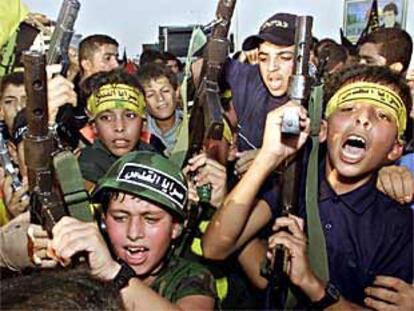 Niños palestinos portan armas y gritan consignas en una marcha organizada por Yihad Islámica y Hamás en Gaza.