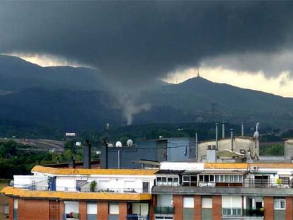 El tornado, captado ayer desde un edificio de Mollet del Vallès.
Este coche fue arrastrado hasta el mar desde una riera de Montgat.