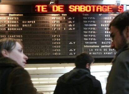 Viajeros observan una pantalla en la estación de Montparnasse en la que se da cuenta del sabotaje en el TGV.