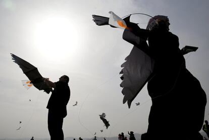 La gente se prepara para volar cometas en el Día Mundial de las Aves Migratorias en la ciudad de Aqaba (Jordania).