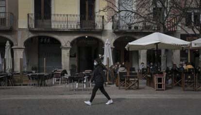 Una noia passeja per la plaça de l'Ajuntament d'Igualada.