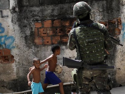 Crianças observam patrulhas das forças armadas no Rio de Janeiro.