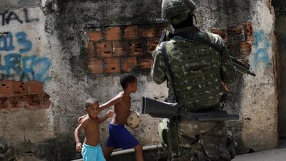 Crianças observam patrulhas das forças armadas no Rio de Janeiro.