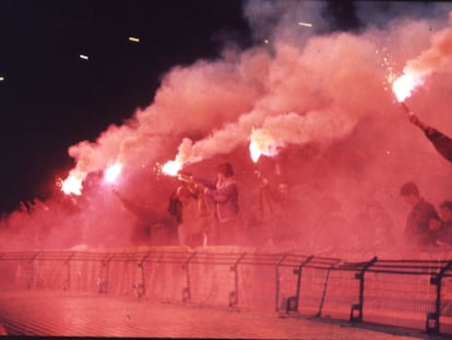 Miembros de los Boixos Nois saludan con bengalas a los jugadores del Barça,  en enero de 1991.