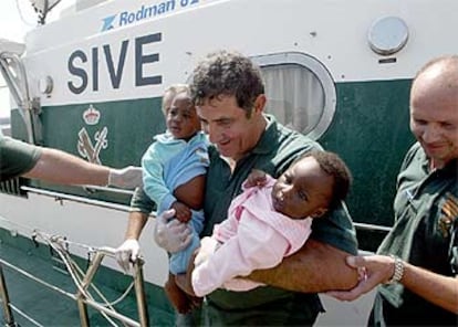 Un guardia civil desembarca en Tarifa (Cádiz) a dos bebés localizados a bordo de una patera.