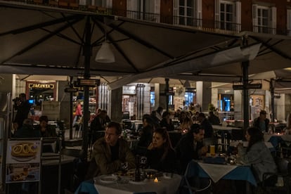 Clientes de un bar de la Plaza Mayor de Madrid, durante el apagón.