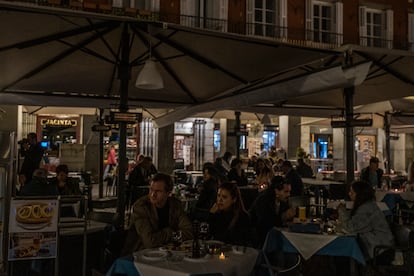 Clientes de un bar de la Plaza Mayor de Madrid, durante el apagón.
