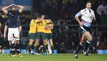 Australia celebra el triunfo ante Escocia mientras el árbitro sale corriendo del campo, en Londres.