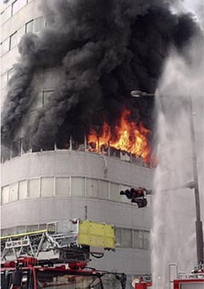 Los bomberos tratan de contener el incendio desatado en la cuarta planta del edificio tras la deflagración.