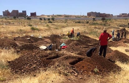 Trabajadores cavan fosas en un descampado del cementerio de Nador, este domingo.