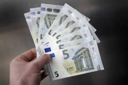 Una persona muestra billetes nuevos de 5 euros. EFE/Archivo