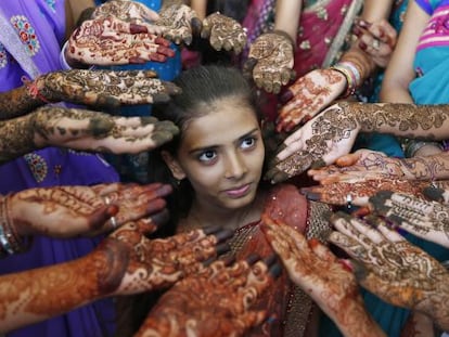 Un grupo de escolares muestran sus manos decoradas con henna en la ciudad india de Ahmedabad.