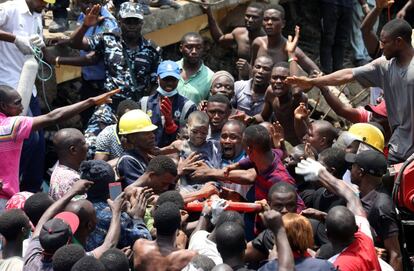 Varias personas murieron y al menos diez niños quedaron atrapados por el derrumbe de un edificio en un barrio popular de Lagos (Nigeria), donde había una escuela primaria en el último piso, indicaron los servicios de socorro. En la imagen, un niño es rescatado del interior de los escombros, el 13 de marzo de 2019.