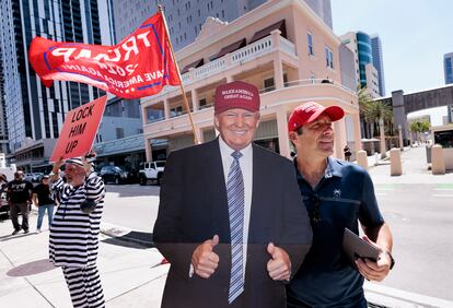 Un seguidor de Donald Trump junto a una imagen en tamaño real del exmandatario, en las inmediaciones de la corte de Miami.