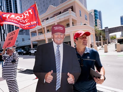 Un seguidor de Donald Trump junto a una imagen en tamaño real del exmandatario, en las inmediaciones de la corte de Miami.