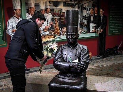 Un hombre deja un ramo de flores en la estatua de Bocuse en su restaurante en Lyon.