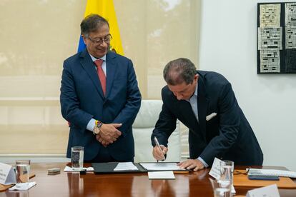 El mandatario colombiano, Gustavo Petro, y al presidente de los ganaderos, José Félix Lafaurie (d), mientras firman un acuerdo de compra de tierras para la reforma agraria, en Bogotá, el 8 de octubre.