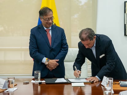 El mandatario colombiano, Gustavo Petro, y al presidente de los ganaderos, José Félix Lafaurie (d), mientras firman un acuerdo de compra de tierras para la reforma agraria, en Bogotá, el 8 de octubre.
