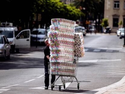 Un trabajador transporta una remesa de rollos de papel higiénico con destino a un supermercado de Málaga.