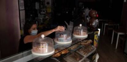 Una empleada de una cafetería de Santa Cruz de Tenerife durante el apagón eléctrico que ha afectado este miércoles a la isla de Tenerife.