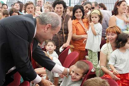 Manuel Chaves saluda a uno de los niños que ayer empezó el curso en el colegio público Nuestra Señora de la Salud de Posadas (Córdoba).