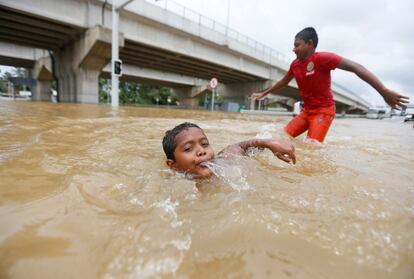 Un niño nada en una carretera inundada por las fuertes lluvias en Kaduwela, Sri Lanka.