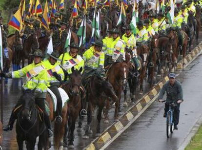 Un ciclista pasa junto a los soldados y policías que participaron ayer en una de las conmemoraciones previas al día oficial de la Independencia.