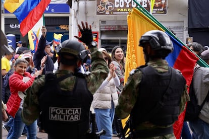 Ciudadanos saludan a integrantes de la policía militar, durante la marcha de este miércoles.