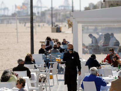 Un camarero atiende las mesas de una terraza en uno de los restaurantes de la playa de la playa de la Malvarrosa de Valencia el 15 de marzo.