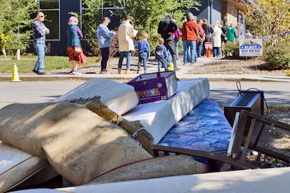 Asheville residents line up near Hurricane Helene debris to cast their ballots on the first day of early voting.