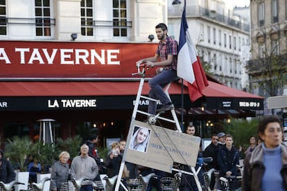Un joven recorre las calles de París con el retrato de una de las víctimas del atentado.
