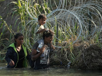 A family arrives by river at Eagle Pass, Texas, an area heavily guarded by police and the National Guard.