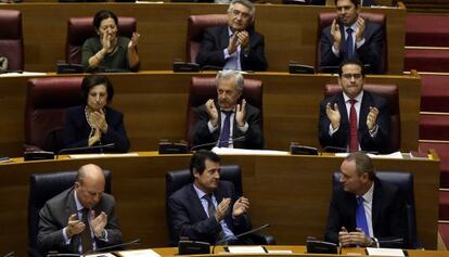 Miembros del Consell y diputados del PP aplauden este jueves la aprobación de los presupuestos.