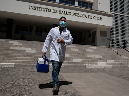 Um trabalhador de saúde caminha em frente ao Instituto Chileno de Saúde Pública, em Santiago, após a autorização do uso da vacina Pfizer.