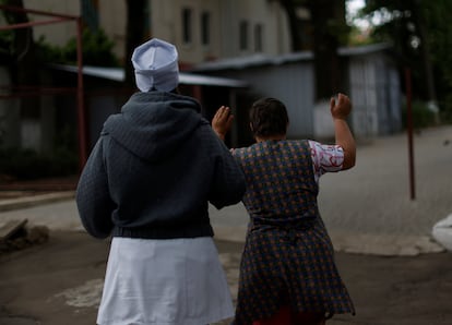 La ONU advierte de que algunos niños podrían estar expuestos a la violencia o a la trata de personas, aunque no se han presentado pruebas concretas y Reuters no lo ha podido comprobar de forma independiente. En la imagen, la enfermera Ekaterina Masiuk conduce a un residente a un refugio en el sótano del internado debido a un aviso de ataque aéreo en junio de 2022.