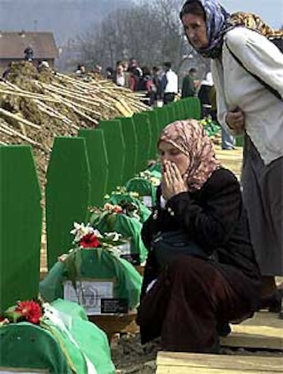 Dos mujeres bosnias, junto a las tumbas de los muertos en Srebrenica.