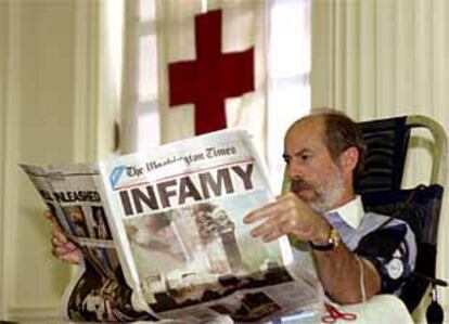 Un policía lee <i>The Washington Times</i> mientras dona sangre en la sede de la Cruz Roja de Washington.
