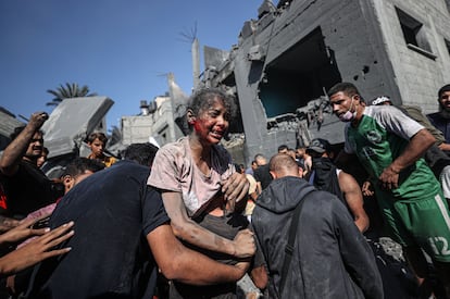 Varios hombres palestinos transportan a una niña víctima de un bombardeo israelí, tras ser rescatada de entre los escombros, este jueves en la ciudad de Jan Yunis.
