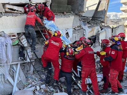 Rescatistas llevan a una mujer después de ser evacuada de debajo de un edificio derrumbado tras un terremoto, en Turquía, 7 de febrero.