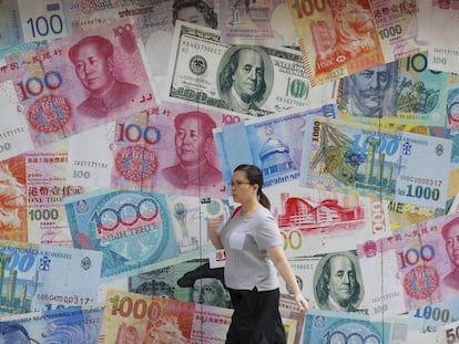 Una mujer pasa junto a una oficina de cambio en Hong Kong.