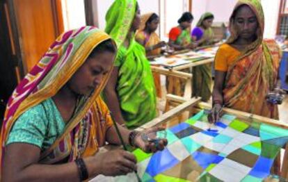 Mujeres treballen pintant mocadors en India.
