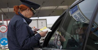 Una policía hungara comprueba la documentación de un conductor que quiere cruzar hacia Croacia.