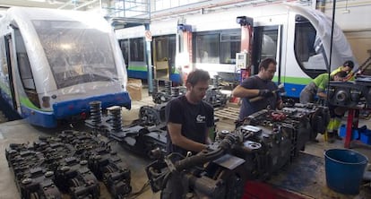 Unos operarios preparan los coches para su traslado a Australia.