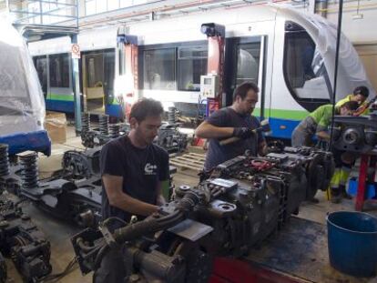 Unos operarios preparan los coches para su traslado a Australia.