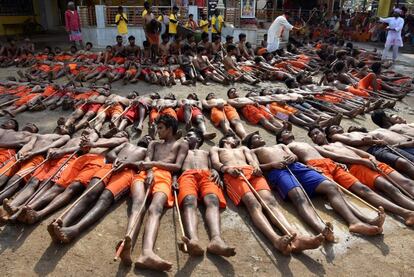 Un grupo de granjeros indios se tumban con palos en las afueras del tempo de Shiva mientras esperan a ser bendecidos por el sacerdote principal durante el festival Manda, en Ranchi (India).