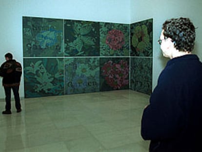 Dos visitantes de la exposición del Palacio Episcopal de Málaga, junto a una obra.