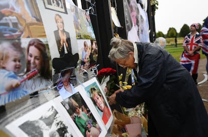 Una mujer coloca flores en homenaje a la princesa Diana de Gales.