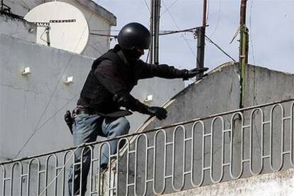 Un policía accede al edificio por una azotea colindante.